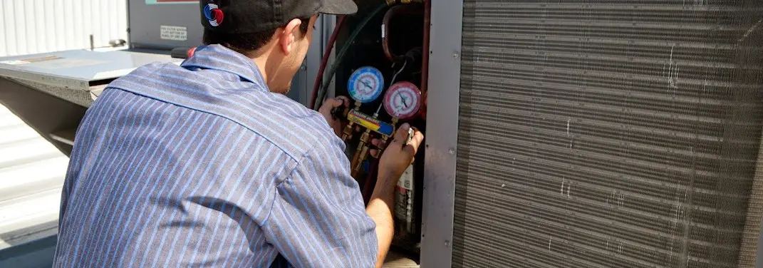 HVAC technician servicing a condenser unit in Mechanicsville