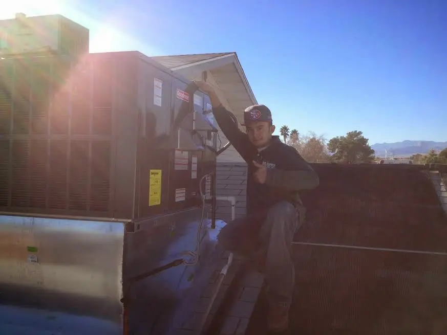 HVAC technician performing AC Tune-Up on a rooftop unit in Mechanicsville